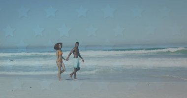 Sahilde yürüyen mutlu Afro-Amerikan çifti yerine yıldızların görüntüsü. Romantik aşk, ilişki ve birliktelik kavramı dijital olarak oluşturulmuş görüntü.