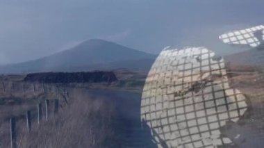 Kırsal çit direklerinin üzerinde yüzen kalın mavi metalik NEWS yazıları ve kablo çerçeveli taş duvarlar. Yayın, medya, iletişim, dijital, küresel, teknoloji, manzara