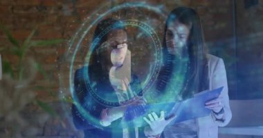 Ofisteki panoyu inceleyen kadınlar, holografik Bitcoin simgesi ve animasyon finans grafiği gösteriyorlar. İşbirlikçiler, yenilik, teknoloji, profesyonel, dijital, girişim, takım çalışması