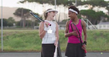 Sahada durmuş raketlerin üzerinde yüzen animasyon sağlık grafikleriyle sohbet eden iki kadın tenis takımı. Atletizm, eğlence, coşku, takım çalışması, açık hava, spor, eğlence.