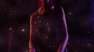 Animasyon dumanlı sis kıvılcımları ve mor ışıklarla müzik sahnesinde gülümseyen kadın sanatçı. Performans, sanatçılık, sahne, canlı, dinamik, kutlama, eğlence