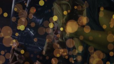 Sahne ışıkları altında akıllı telefon, müzik pazarlaması için altın bokeh ile metal kiriş kullanan arkadaşlar. Konser, gece hayatı, eğlence, cazibe, kutlama, ambians, şehir