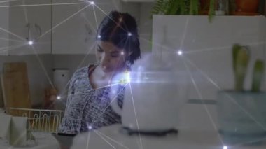 Yetişkin bir kadın mutfak içinde tablet tıkırdatıyor. Parlak ağ kaplamalı akıllı ev teknolojisi kullanıyor. Gelecekçi, minimalist, dijital, teknoloji, konforlu, çağdaş, bağlantı