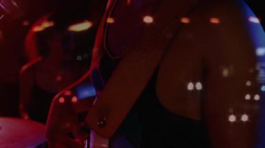 Erkek şarkıcı, renkli ışıklar altında mikrofonla müzik sahnesinde canlı performans sergiliyor. Müzisyenler, eğlence, konser, canlı, performans, gece hayatı, sanatsal