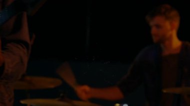 Müzik stüdyosunda klasik mikrofona yaslanan erkek şarkıcı, ışık ve canlandırılmış kıvılcım efektleriyle. Performans, ses, eğlence, vintage, sanatçılık, ifade, sahne