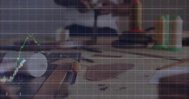 Adam ahşap çalışma masasında işçilik aletini ayarlıyor, finans tablosunu renkli çizgilerle örtüyor. Sanatçılık, yaratıcılık, kesinlik, yenilik, zanaatkar, el yapımı, üretkenlik