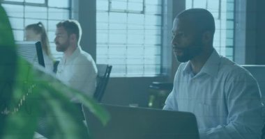 Ofis profesyonelleri, dizüstü bilgisayarların üzerinde yüzen animasyon veri çizelgeleriyle iş ofisinde çalışıyor. İşbirliği, verimlilik, açık ofis, yenilik, takım çalışması, çağdaş, çalışma alanı