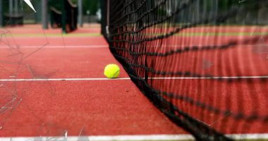 Kırmızı sahada siyah ağın yanında iki sarı tenis topu yatıyordu. Beyaz çizgili, düz dizaynlı. Spor, etkinlik, eğlence, açık hava, canlı, enerjik, rekabetçi