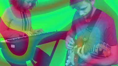 Stüdyoda kırmızı gitar çalan adamın yanında klavye çalan kadın, neon müzik notalarıyla. İşbirliği, yaratıcılık, canlılık, uyum, performans, canlı müzik, eğlence