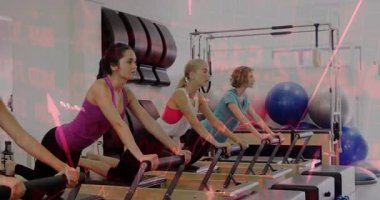 Stüdyoda, şeffaf kırmızı finans grafiklerini kaplayan pilates reformatörü egzersizleri yapan kadınlar. Spor, sağlık, güç, kardiyo, modern, işbirlikçi, sağlık