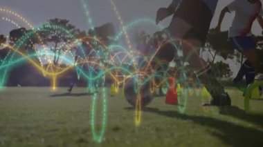 Dişi futbolcular sahada külahta top sürerken, spor teknolojisi dalga grafikleriyle. Atletik, takım çalışması, yenilik, spor alanı, dijital, performans, motivasyon