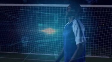 Gece stadyumunda parlayan futbol topunu tutan kaleci neon veri hatlı spor teknolojisini gösteriyor. Atletik, fütüristik, yenilikçi, dijital, enerjik, gece, spor