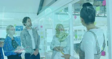 Pazarlama ekibi cam bölme etrafında işbirliği yapıyor, tablet tutuyor, notlar gösteriyor, çizimler yapıyor. İşbirliği, yenilik, takım çalışması, beyin fırtınası, modernlik, çeşitlilik, yaratıcılık süreci