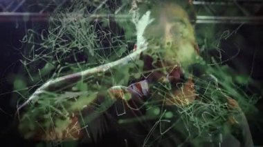 Sahnede mikrofona cam tutarak yeşil ağ kaplamalı teknolojiyi gösteren bir solo sanatçı. Performans, eğlence, sahne, dijital, fütüristik, karamsar, spot ışıkları