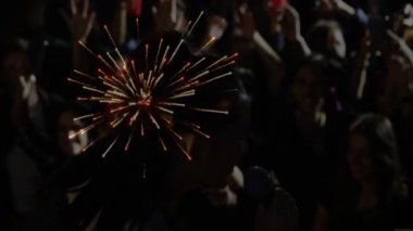 Oyuncu silueti sahnede mikrofon sallıyor, hayranlar müzik için telefonlara kıvılcım saçıyor. Gece hayatı, konser, enerji, kalabalık, atmosfer, canlı, kutlama