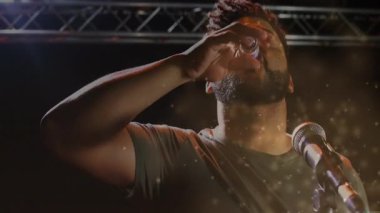 İnsanlar müzik sahnesinde mikrofona altın parçacıklar serpiyor, canlı eylemleri animasyon verileriyle harmanlıyor. Performans, sahne, sahne ışığı, kutlama, eğlence, dinamik, tiyatro