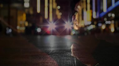 Erkek şarkıcı, neon ışıklı caddede mikrofon tutuyor ve müziği ıslak kaldırımla iki kez birleştiriyor. Performans, gece hayatı, şehir, karamsar, stil, eğlence, canlı