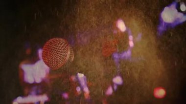 Müzik ikilisi müzik sahnesinde mikrofona şarkı söylüyor. Animasyon dalgalanmaları, ışık simgeleri var. Performans, ses, eğlence, dinamik, canlı, sanatsal, konser