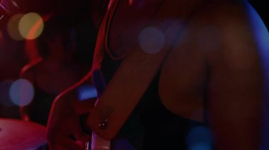 Erkek vokalist konser sahnesinde canlı ses dalgaları ve parlayan ışıklarla performans sergiliyor. Performans, konser, müzik, eğlence, canlı, enerjik, gece hayatı