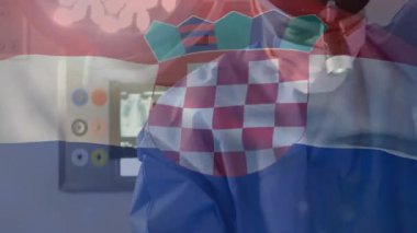 Erkek cerrah, tıbbi ameliyathanede kontrol panelini ayarlayıp Hırvat bayrağını harmanlıyor. Cerrahi, sağlık, tıbbi, işletme, kesinlik, klinik, teknoloji