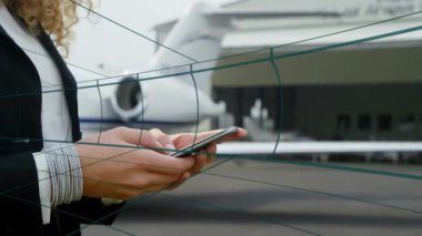 İş kadını, akıllı telefonu asfalt apronla dinliyor. Animasyon uçuş çizelgesi ve verileri gösteriyor. Profesyonel, modern, gösterişli, ulaşım, şirket, teknoloji, açık hava
