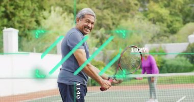 Yeşil kortta tenis topu servis eden kıdemli bir adam, hareket grafiği ve kalp ikonu sağlığını gösteriyor. Açık hava sporları, eğlence aktivitesi, sağlıklı yaşam tarzı, aktif yaşlanma, spor, eğlence, canlı