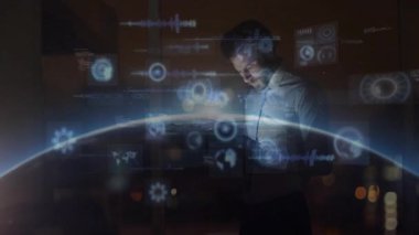 Tişört giyen ve kravat takan bir işadamı, holografik küreyi ve çalışma alanındaki veri grafiklerini analiz ediyor. Gelecekçi, yenilikçi, dijital, teknoloji, analitik, çalışma alanı, şirket