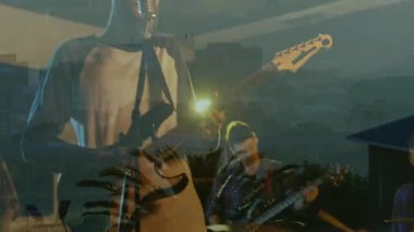 Rock grubu üyeleri yeşil renkli sahnede performans sergiliyorlar, animasyon şehir silueti ve palmiye ağaçları yansıtıyorlar. Müzisyenler, canlı müzik, sahne tasarımı, neon ışıklandırma, şehir atmosferi, sanatsal performans, konser düzeneği