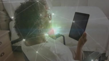 Tekerlekli sandalyedeki yaşlı kadın elinde tabletle sağlık teknolojisi grafikleri ve dijital linkler gösteriyor. Yaşlılar, asisteknoloji, refah, konfor, iletişim, modern, sağlık hizmetleri