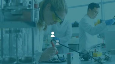 Elektronik araştırmacılar laboratuarda lehimleme devresi oluşturuyorlar, animasyon veri haritaları sunuyorlar. Teknoloji, yenilik, işbirliği, mühendislik, prototip, hassasiyet, yaratıcılık