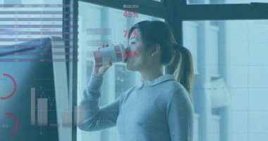 Ofiste kağıt bardaktan içen, teknoloji grafikleri ve küresel veri örtüleri sergileyen bir kadın. İş, üretkenlik, analitik, kurumsal, yenilik, dijital, profesyonel