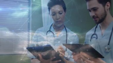 Doktorlar sağlık kliniğindeki panoları ve tabletleri inceliyor, ağ örtüsü ekliyorlar. Sağlık, işbirliği, teknoloji, profesyonellik, dijital, modern, tıbbi personel