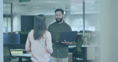 Meslektaşlar açık ofiste iş planlarını tartışıyor, dizüstü bilgisayarın üstünde animasyon çizelgeleri gösteriyorlar. İşbirliği, takım çalışması, iletişim, modern, profesyonel, çalışma alanı, yenilik