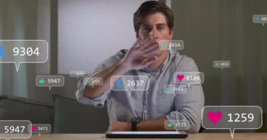 Masaya uzanan bir adam, yüzen sosyal medya ölçümleri ve simgeleriyle etkileşime geçiyor. Teknoloji, katılım, analitik, dijital, iletişim, modern, çalışma alanı