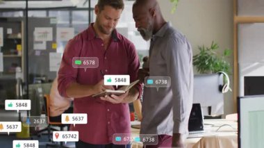 İki iş arkadaşı, pazarlama ofisinde yüzen sosyal medya simgelerini göstererek defter üzerinde işbirliği yapıyorlar. İşbirliği, takım çalışması, üretkenlik, modern, işyeri, dijital, iletişim