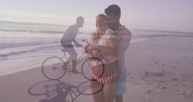 Sahil şeridinde kucaklaşan romantik çift, sağlık verilerini vurgulayan animasyon kalp ikonuyla. Romantizm, bağlantı, eğlence, manzara, yaşam tarzı, sükunet, minimalist