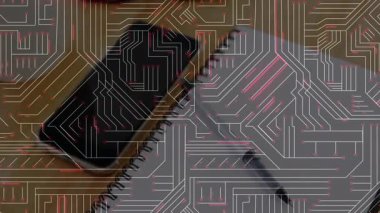 Siyah akıllı telefon ahşap masada yüzüstü duruyor. Devre kartı kaplamasını defter gözlükleriyle gösteriyor. Teknoloji, çalışma alanı, yenilik, minimalizm, üretkenlik, elektronik, modern