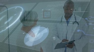 Hasta muayene odasında elinde dosya tutan erkek doktor, holografik çizelgeleri gösteriyor. Sağlık, teletıp, biyomedikal, klinik, danışma, dijital, tanı