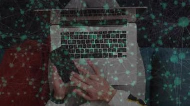 Teknoloji sahnesinde akıllı telefon ve dizüstü bilgisayar kullanan bir adam animasyon yeşil veri ağı örtüsü sergiliyor. Teknoloji, bağlantı, dijital, iletişim, yenilik, çalışma alanı, modern