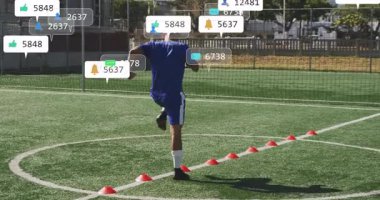 Futbol oyuncusu spor antrenman sahasında konilerin üzerinden atlıyor, sosyal medya çağrıları yapıyor. Atletik, antrenman, hareket, spor, açık hava, enerjik