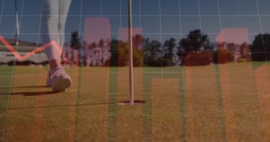 Finans uzmanı golf yeşili üzerinde kırmızı çizelgeleri ve aşağı ok grafiğini gösteriyor. Spor, eğlence, analitik, strateji, açık hava, sağlık, yaşam tarzı.