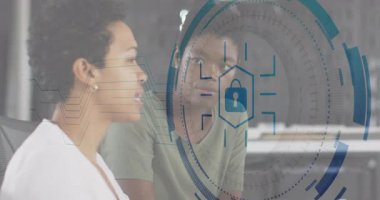 İki meslektaş ofis masasında siber güvenliği tartışıyor, yüzen asma kilit ve arayüz var. İş, işbirliği, yenilik, teknoloji, minimalizm, profesyonellik, veri koruması