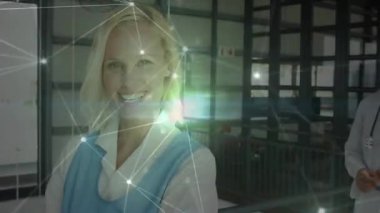 Doktor ve hemşire hasta verilerini tartışıyor, hastane koridorunda parlayan bir ağ var. Tıbbi, işbirliği, fütüristik, sağlık, teknoloji, profesyonellik, yenilik