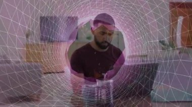 Akıllı telefonu tutan ve teknoloji atölyesinde dizüstü bilgisayar kullanan adam bağlı ağ örtüsünü gösteriyor. İş, üretkenlik, modern, yenilik, iletişim, uzak, dijital