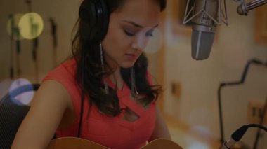 Müzik stüdyosunda ses kaydeden bir kadın, mikrofon etrafında titreşen animasyon ses dalgaları sergiliyor. Ses, müzik üretimi, kayıt, profesyonel, akustik, yaratıcı, vokalist