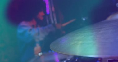 Davulcu müzik reklamı için bagetlerle zil çalıyor. Canlandırılmış ses dalgaları yükseliyor. Alet, performans, konser, stüdyo, ritim, melodi, görsel