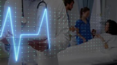 Kadın hemşire yatak monitörünü düzeltirken, erkek doktor hastane koğuşundaki EKG tablosunu inceliyor. Tıbbi, sağlık, tanı, profesyonel, klinik, hastane, teknoloji