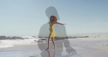 Kadın kıyı şeridinde yalınayak dans ediyor, pazarlama için sarı elbiseli yarı saydam silueti gösteriyor. Yolculuk, huzur, uyum, yansıma, doğal, sanatsal, canlı