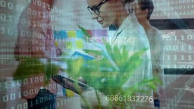 Teknoloji ofisindeki tablet üzerine yazan kadın iş arkadaşı ikili kod akışları ve yapışkan notları gösteriyor. İşbirliği, yenilik, dijital, işyeri, beyin fırtınası, teknoloji, bağlantı
