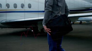 Business sperson özel jetin yanında asfalt üzerinde duruyor, yüzen finans çizelgesi çizgileri gösteriyor. Şirket, ulaşım, analiz, yürütme, uçuş, hareketlilik, strateji